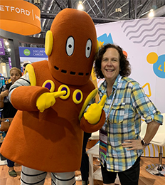 Female staff member poses with Brain Pop character Moby