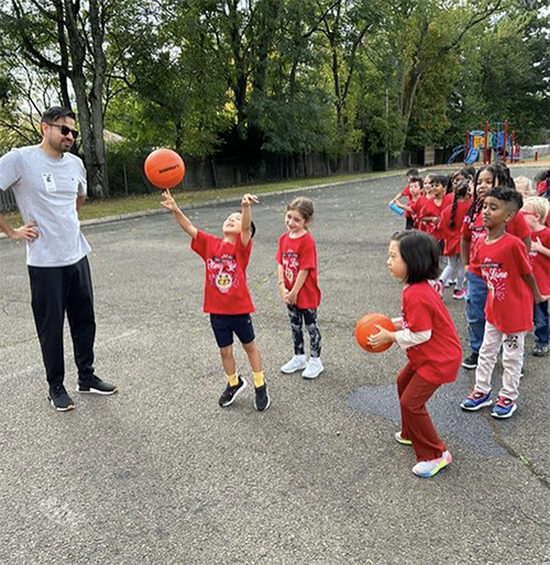 Teacher and students on basketball court