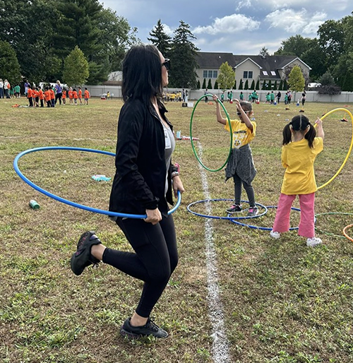 Teacher and students having fun with hula hoops