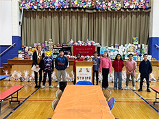 Group of students with teacher in front of Thanksgiving food drive